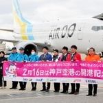 開港記念日を祝い、横断幕を広げる航空会社などの社員ら＝神戸空港