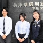 播州織の（左から）シャツとブラウス、リボンタイを着用する兵庫県信用組合の職員。普段はジャケットを羽織っている＝神戸市中央区栄町通３、本店営業部
