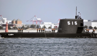 三菱重工業神戸造船所からの引き渡し式後、潜水艦「じんげい」の上で感謝の言葉を掲げる海上自衛隊の乗員ら＝８日午後、神戸港