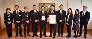 「神戸登山プロジェクト」に１００万円を寄付したあいおいニッセイ同和損害保険の中沢龍太神戸支店長（右から５人目）と神戸市の今西正男副市長（同６人目）ら＝神戸市役所