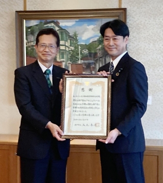「神戸登山プロジェクト」に１００万円を寄付したあいおいニッセイ同和損害保険の中沢龍太神戸支店長（右）と神戸市の今西正男副市長＝神戸市役所