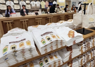 「イスズベーカリー」とコラボしたオリジナルＴシャツなどが並ぶ売り場＝２７日午前、神戸市中央区三宮町１、ユニクロ神戸三宮店（撮影・長嶺麻子）