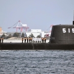 三菱重工業神戸造船所からの引き渡し式後、潜水艦「じんげい」の上で感謝の言葉を掲げる海上自衛隊の乗員ら＝８日午後、神戸港
