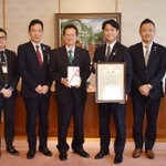 「神戸登山プロジェクト」に１００万円を寄付したあいおいニッセイ同和損害保険の中沢龍太神戸支店長（右から５人目）と神戸市の今西正男副市長（同６人目）ら＝神戸市役所