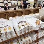 「イスズベーカリー」とコラボしたオリジナルＴシャツなどが並ぶ売り場＝２７日午前、神戸市中央区三宮町１、ユニクロ神戸三宮店（撮影・長嶺麻子）