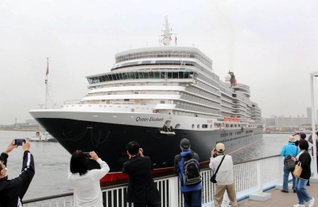 神戸港に入港するクイーン・エリザベス。神戸ポートターミナルでは市民らがカメラを向けた＝18日午前７月48分、神戸市中央区（撮影・大島光貴）