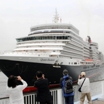 神戸港に入港するクイーン・エリザベス。神戸ポートターミナルでは市民らがカメラを向けた＝18日午前７月48分、神戸市中央区（撮影・大島光貴）