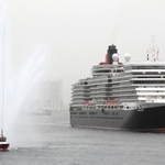 神戸港に入るクイーン・エリザベス。神戸市の消防艇が歓迎放水した＝18日午前７時32分、神戸市中央区（撮影・大島光貴）