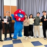 木下記念事業団の二星康親専務理事（左端）に入場券の目録を手渡す、三菱ＵＦＪ信託銀行の岡林茂伸大阪法人営業部長。大学生や万博キャラクターのミャクミャクも駆け付けた＝神戸市内（提供）