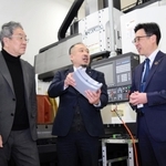 樹脂の精密切削装置の前で、三田電気工業の中村哲哉社長（中央）を囲むひょうご専門人材相談センターの亀井芳郎さん（左）と日新信用金庫の橘宏明さん＝神戸市西区見津が丘５