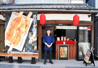 五平餅を販売する店舗「米と黒豆」の前に立つ大坂宇津実さん＝丹波篠山市二階町