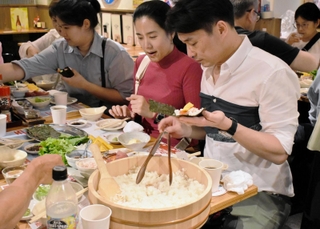 兵庫県産食材を使って手巻きずしを作る訪日客ら＝神戸市中央区北長狭通２、ひょうご五国ワールド神戸三宮横丁（ワールド・ワン提供）