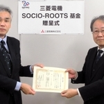 神戸市社会福祉協議会の玉田敏郎理事長（右）に贈呈書を手渡す三菱電機神戸製作所総務部の中島栄吉さん＝神戸市中央区磯上通３