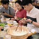 兵庫県産食材を使って手巻きずしを作る訪日客ら＝神戸市中央区北長狭通２、ひょうご五国ワールド神戸三宮横丁（ワールド・ワン提供）