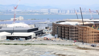 約９割が組み上がった木造巨大屋根「リング」（右）と建設が進むパソナグループのパビリオン＝12日午前、大阪市此花区