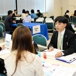 学生に事業内容を説明する企業の担当者（右）＝神戸市中央区東川崎町１、神戸クリスタルホール