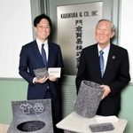 リサイクル素材「リフモ」の加工品を持つ門倉貿易の門倉功一郎社長（左）と門倉建造会長＝神戸市中央区海岸通