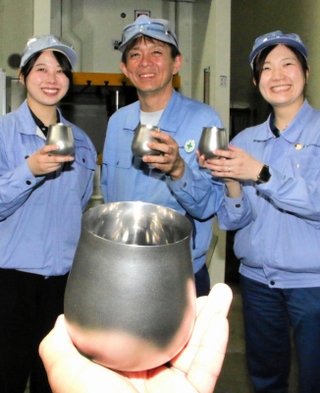 カネミツが作ったハイボールタンブラーと、新規事業プロジェクトに携わった（左から）松村理沙さん、松井麗公さん、野口沙耶夏さん＝加西市網引町丸山、同社テクニカルセンター