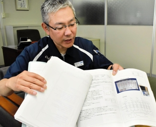 紙でまとめられた「技術ノート」を手にするカコテクノスの加古泰三社長。受注生産した製品の仕様や技術、工夫点などが書き込まれている＝小野市北丘町、カコテクノス小野工場