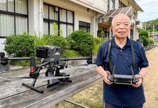 ドローン操縦士養成学校のグラウンドでコントローラーを手にするＴ＆Ｔの前田稔朗会長＝兵庫県佐用町豊福