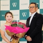 メジャー制覇を祝う花束を、和田興産の溝本俊哉社長（右）から受け取った女子ゴルフの古江彩佳選手＝２２日午前、神戸市中央区栄町通４、同社