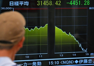 日経平均株価の終値がモニターに表示され、足を止める人の姿がみられた＝５日午後、神戸市中央区の三宮センター街（撮影・斎藤雅志）