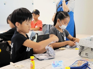 布の端切れを活用し、フォトフレーム作りに挑む子どもたち＝神戸市中央区港島中町６、ワールド