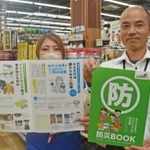 ホームセンターアグロが作成した「防災ブック」。寺田貴さん（右）ら社員チームで内容をまとめた＝神戸市長田区南駒栄町