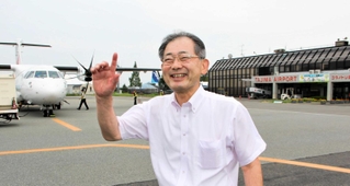 駐機場に立つ但馬空港ターミナルの桐山徹郎社長。「小型機で関西空港や神戸空港から飛んできて、但馬を周遊するツアーも提案している」＝豊岡市岩井、但馬空港