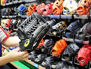 アシックス製品（手前）などさまざまなメーカーの軟式用グラブが並ぶ陳列棚＝神戸市中央区、スーパースポーツゼビオ神戸ハーバーランド店