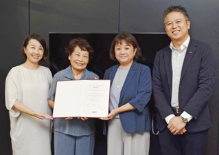 ドコモＣＳ関西の大石望・神戸支店長（右）から贈呈書を受け取った日本多胎支援協会の理事３人＝神戸市中央区小野柄通４