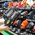 アシックス製品（手前）などさまざまなメーカーの軟式用グラブが並ぶ陳列棚＝神戸市中央区、スーパースポーツゼビオ神戸ハーバーランド店