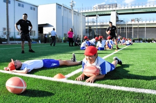 ふかふかの人工芝に寝そべる子どもら＝神戸市東灘区御影浜町、コベルコスポーツパーク