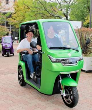 納車されたＥＶトゥクトゥクに試乗する学生ら＝神戸市北区鈴蘭台北町７、神戸親和大