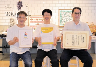 これまでの認定証や表彰状を手にする（左から）笹倉清明営業課長、竹内裕児代表取締役、竹内孝佳常務＝兵庫県多可町中区糀屋、ソーイング竹内