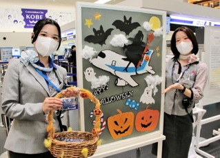 神戸空港のＡＮＡカウンターでは手作りのハロウィーンのポスターを飾り、お菓子を配っている＝29日午前、神戸市中央区