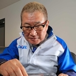 小さなガラス板に彫った溝に液体を入れ化学反応を起こす「マイクロプラント」について説明するダイセルの小河義美社長＝たつの市揖保川町馬場、同社播磨工場（撮影・小林良多）