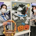 神戸空港のＡＮＡカウンターでは手作りのハロウィーンのポスターを飾り、お菓子を配っている＝29日午前、神戸市中央区