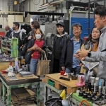 参加者に工場を案内しながら金型の製作工程を説明する「エー．ティ．エム」の青木崇敏社長（右端）＝神戸市須磨区大池町５