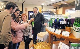 酒造用具などの見学後、直売所に並ぶ日本酒を品定めする訪日客＝神戸市東灘区魚崎西町１、菊正宗酒造記念館