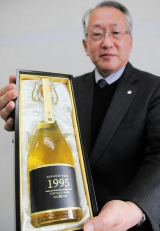 阪神・淡路大震災直後に仕込み、３０年熟成した沢の鶴の「１９９５年醸造　生酛純米古酒」と西向賞雄取締役製造部部長＝神戸市中央区港島中町６、神戸商工会議所