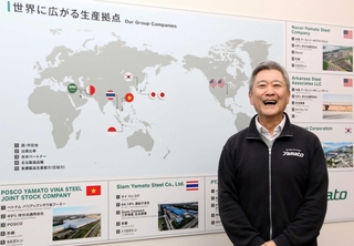 新社屋の展示室に掲げられた世界地図の前に立つ大和工業社長の小林幹生氏。特に三井物産時代の米国勤務が印象深いという＝姫路市大津区吉美