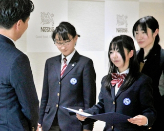 ネスレ日本の深谷龍彦社長（左）から表彰状を受け取った兵庫県立大付属中学校の生徒たち＝神戸市中央区御幸通７、ネスレ日本