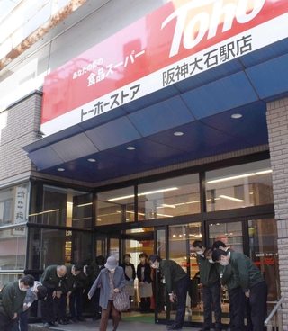 トーホーストア最後の営業日、最後の客を送り出す阪神大石駅店の従業員ら＝１１月２１日、神戸市灘区船寺通１