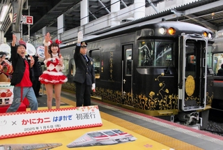 渡辺弘幸大阪駅長と「かつみ・さゆり」の合図に合わせ、出発する「はなあかり」と「かにカニはまかぜ」＝ＪＲ大阪駅