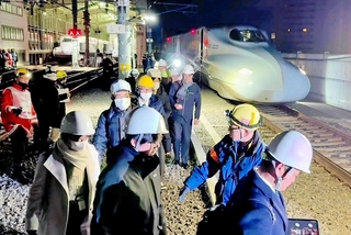 大地震を想定した避難誘導訓練で、停車した新幹線から降りて線路を歩く乗客役ら＝１６日未明、ＪＲ新大阪駅付近