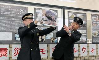 展示パネルの前で、阪神・淡路大震災で脱線した車両に乗り合わせた当時の経験を、写真を示しながら語る阪急電鉄の西田敏和さん（右）＝西宮北口駅