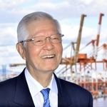 コンテナターミナルを背に、神戸港の未来を語る日本港運協会の久保昌三会長＝神戸市中央区港島９