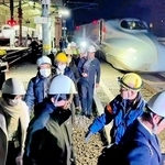 大地震を想定した避難誘導訓練で、停車した新幹線から降りて線路を歩く乗客役ら＝１６日未明、ＪＲ新大阪駅付近