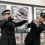 展示パネルの前で、阪神・淡路大震災で脱線した車両に乗り合わせた当時の経験を、写真を示しながら語る阪急電鉄の西田敏和さん（右）＝西宮北口駅